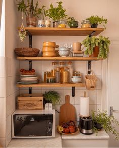 a kitchen shelf filled with pots and pans next to a toaster oven on top of a counter