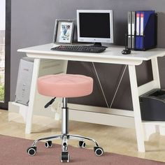 a computer desk with a pink stool in front of it