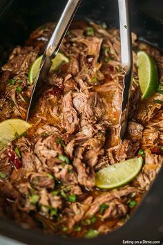 two tongs are being used to stir pulled pork into the slow cooker and garnish it with cilantro