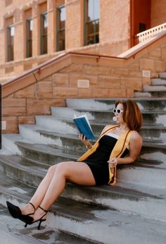 a woman sitting on steps reading a book