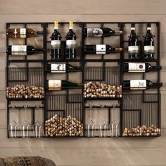 a wine rack filled with bottles and glasses next to a wall mounted wine glass holder