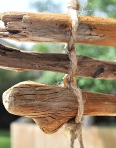 an old wooden structure with rope hanging from it