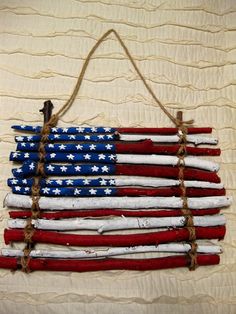 an american flag made out of sticks and rope hanging on a wall or bed frame