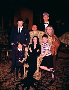 a family posing for a photo in front of a chair with two adults and two children