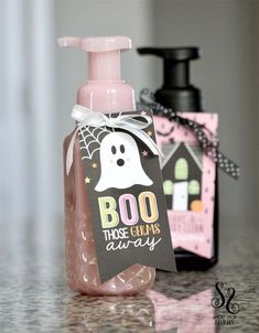 a soap bottle with a ghost tag on it sitting next to a halloween gift bag