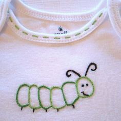 a white shirt with a green caterpillar embroidered on it