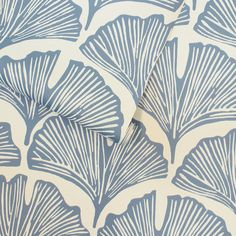 blue and white wallpaper with large leaves on it