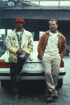 two men sitting on the back of a car