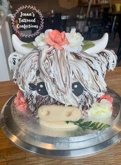 a cake decorated to look like a cow with flowers on its head