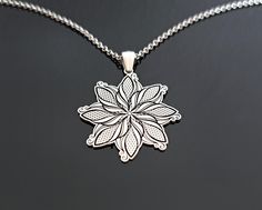 a silver necklace with a flower design on it