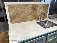 a kitchen counter top with a stainless steel sink and faucet next to it