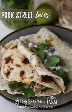 two tortillas are sitting on a plate next to some limes and a mason jar