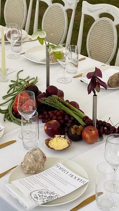 the table is set with many different types of fruits and vegetables on it, including asparagus