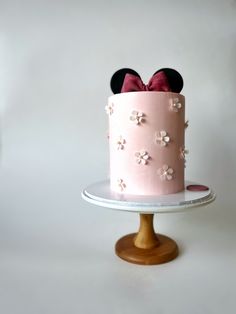 a pink cake with minnie mouse ears on top