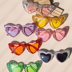 six pairs of sunglasses with different colors and designs on them, all in the shape of hearts