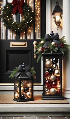 two christmas decorations sitting on top of a door next to a black front door with a wreath