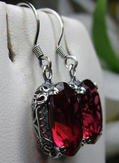 Simulated Red Ruby Solid Sterling Silver Earrings Edward Design#E70 This is a pair of antique-inspired Edwardian style earrings. The flawless oval simulated red Ruby gems are surrounded by delicate sterling silver filigree. The lovely full cut oval stones are approximately 14mm by 10mm in length & width. The earrings are 1.25 inches long and are marked 925 for solid sterling silver. Notice the beautiful floral craftsmanship of the filigree settings. The gemstones are cut to reflect light, cr Ornate Red Sterling Silver Earrings, Red Sterling Silver Filigree Earrings, Victorian Red Oval Earrings, Red Ruby Earrings With Intricate Design, Ornate Oval Red Jewelry, Red Oval Garnet Earrings, Red Garnet Oval Earrings, Red Ruby Earrings, Edwardian Jewelry