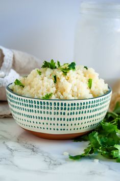 a bowl filled with rice and parsley on top of a table