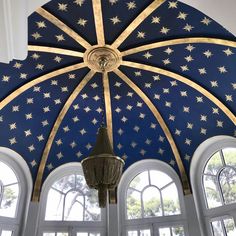 an ornate ceiling with multiple windows and a chandelier