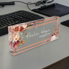 an acrylic box sitting on top of a desk next to a keyboard