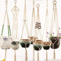 several hanging planters with plants in them and some beads on the hooks attached to them