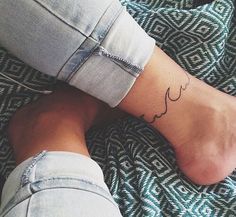 a woman's foot with a small tattoo on her left leg and the word love written