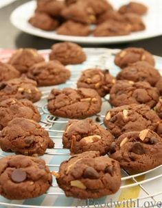 chocolate cookies are cooling on a rack in front of another plate with more cookies behind them