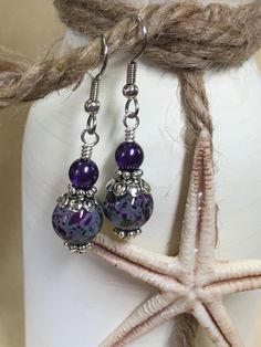 Life is short - wear pretty things! A beautiful pair of purple & olive speckled dangle earrings that will be a great wardrobe accessory. Also a great gift idea. Earrings are made using surgical steel ear wires. I use wrapped loops to give the earring a more finished look. Earrings come with rubber ear backs that slide on to keep earrings from falling out of ears. Color: dark purple, olive green, Deep purple pearl, Earrings length: 1 3/4 inches YOU MAY ALSO LIKE: https://www.etsy.com/shop/Jil Bead Knit, Handmade Birthday Gifts, Birthday Gift For Mom, Wardrobe Accessories, Purple Pearl, Electronic Gifts, Beaded Dangle Earrings, Slide On, Wire Earrings