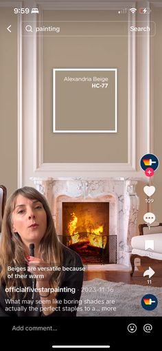 a woman holding a microphone standing in front of a fire place with the caption below