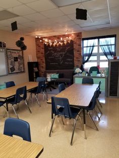 an empty classroom with desks and chairs in front of a chalkboard on the wall