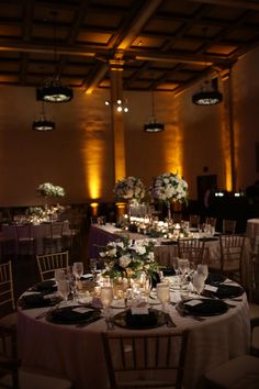 the tables are set up with candles and centerpieces for an elegant wedding reception