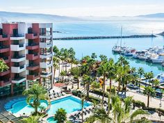 an aerial view of a marina with boats in the water and palm trees surrounding it