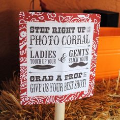 a red and white sign sitting on top of hay