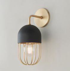 a light that is on the wall next to a white wall with a black shade