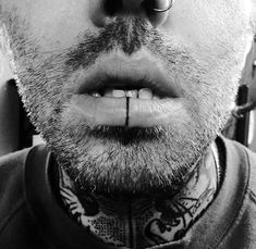 a man with piercings on his nose and neck