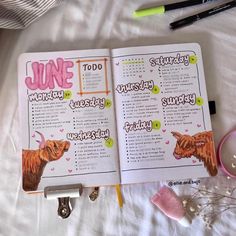 an open notebook with the words june written in pink and green on it next to other items