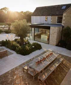 a wooden table sitting in the middle of a patio next to a building and trees