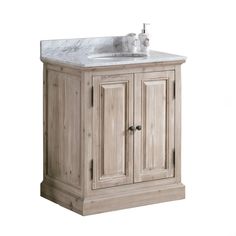 a bathroom vanity with a marble top and two doors on the front, one door open