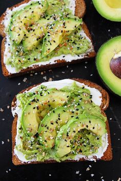 two pieces of bread topped with avocado and sprinkles next to an avocado