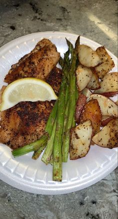 a white plate topped with chicken, asparagus and potatoes