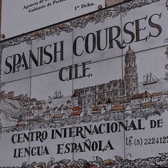 a sign that is on the side of a building with spanish words and pictures around it