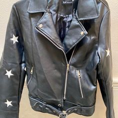 Super Cool Black Pleather Biker Jacket. Has White Stars On Front And Both Arms. Womens Size M. Fully Lined. 100% Polyester. In Great Condition With No Rips, Stains Or Foul Odors! Black Star Print Winter Outerwear, Black Star Print Outerwear For Winter, Black Long Sleeve Outerwear With Star Print, Trendy Winter Outerwear With Star Print, Long Sleeve Star Print Outerwear For Fall, Winter Outerwear With Star Patch And Long Sleeves, Winter Long Sleeve Outerwear With Star Patch, Fall Streetwear Outerwear With Star Print, Fall Star Print Outerwear For Streetwear