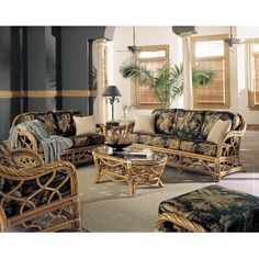 a living room with wicker furniture and palm trees on the wall in it's corner