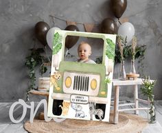 a baby is sitting in the back of a truck with balloons and greenery around it