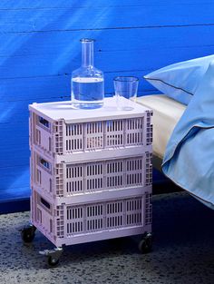 a plastic crate with water in it sitting next to a bed