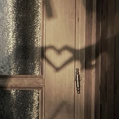 the shadow of a heart is cast on a door