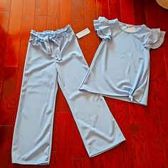 Nwt Baby Blue Two Piece Set. Very Lightweight, Dressy, Gorgeous Set Pants Have Elastic Waist With Working Belt. Waist 11" Unstretched, Inseam 21" Wide Leg, Flowy Size S(7/8) Top Is Size M(10/12). Ptp Almost14" Top To Bottom Is 21" With Ruffle Short Sleeves Cotton Pant Set For Spring, Spring Cotton Pant Set In Solid Color, Solid Color Cotton Pant Set For Spring, Blue Matching Loungewear Sets, Blue Stretch Short Sleeve Set, Solid Matching Sets For Spring, Spring Matching Set In Solid Color, Light Blue Short Sleeve Sets For Spring, Light Blue Short Sleeve Spring Sets