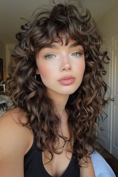 Curly haircuts are all about celebrating your texture and finding a style that complements your face shape. Whether you have loose waves, bouncy spirals, or tight coils, there’s a curly haircut out there that will Long Curly Fringe, 2c Curly Hair Haircuts Bangs, 70s Curly Haircut, Curly Haircut For Oval Face, Curly Hairstyles For Oval Face Shape, Medium Length Curly Hair With Bangs, Hispanic Curly Hair, Curly Hair Shapes, Curly Hair Cuts With Bangs