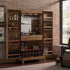 a room with a brick wall and wooden shelves filled with bottles, wine glasses and liquor