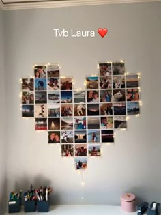 a white desk topped with a heart shaped photo collage next to a wall filled with pictures